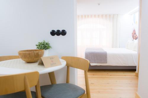 a room with a bed and a table and chairs at Páteo Saudade Lofts in Lisbon