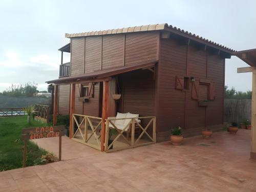 a tiny house with a porch and a patio at Imasaru in Roche