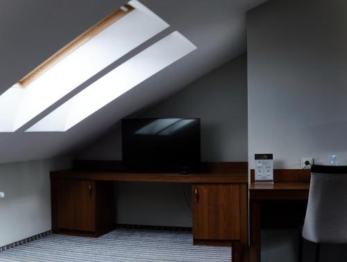 a room with a desk with a television and a skylight at Hotel 4x4 in Rivne