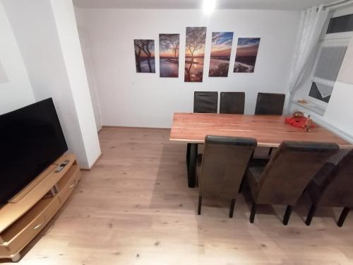 a dining room with a table and chairs and a television at Ferienwohnung Thomas Müntzer in Mühlhausen