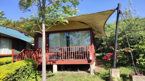 a tree house with a porch and a swing at AA Lodge Maasai Mara in Talek