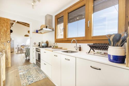 a kitchen with white cabinets and a sink at El Paller De Cal Dominguet in Espluga Calva