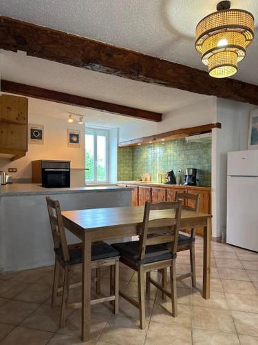 une cuisine avec une table en bois et deux chaises dans l'établissement Maison cosy proche Carcassonne, à Conques-sur-Orbiel