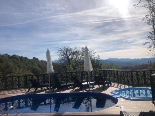a hot tub with chairs and umbrellas on a balcony at Вила Поликсения Петиня in Tryavna