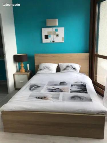 une chambre avec un lit avec un mur bleu dans l'établissement 2 pièces rénové 36 m² - sud avec vue montagne, à Villard-de-Lans