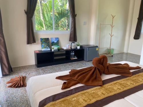 Un dormitorio con una cama grande con una toalla encima. en Arya Bungalow, en Phra Ae beach