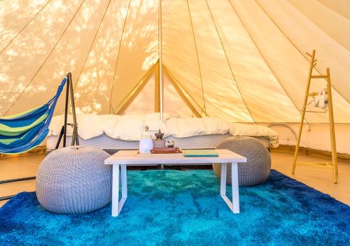 a room with a tent with a table and two balls at Takatakiko Glamping Resort in Tsurumai