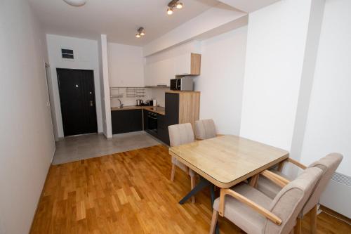 a kitchen and dining room with a wooden table and chairs at Luxury Apartments Valentino in Ohrid