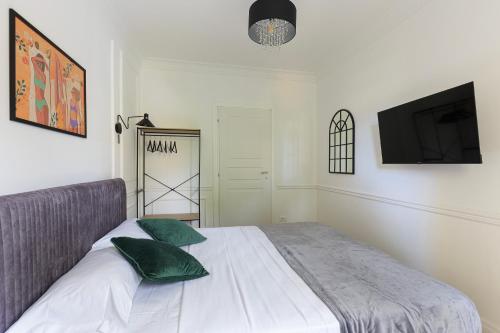 a bedroom with a bed with green pillows and a tv at Sense Rooms in Baveno