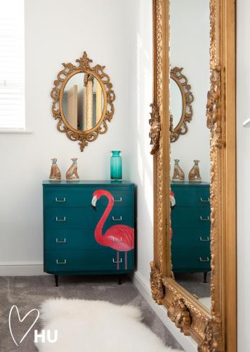 a mirror next to a dresser with a flamingo painted on it at Sky Marina Suite Penthouse in Hull