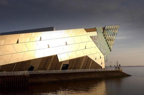 a building with lights on the side of a body of water at Sky Marina Suite Penthouse in Hull