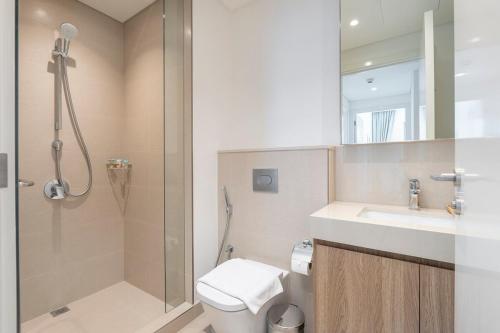 a bathroom with a shower and a toilet and a sink at Free housekeeping visits during your stay - StayShort - Beautiful 2-BR Flat in Downtown Luxury City Living at Its Best in Dubai