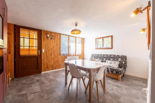 une salle à manger avec une table, des chaises et un canapé dans l'établissement Le Bellevarde - Appt 10min station de Megève, à Praz-sur-Arly