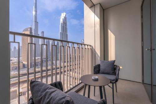a balcony with two chairs and a table with a view at Free housekeeping visits during your stay - StayShort - Beautiful 2-BR Flat in Downtown Luxury City Living at Its Best in Dubai