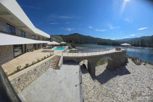 a building with a bridge next to a body of water at Orlovo gnezdo in Ljubovija