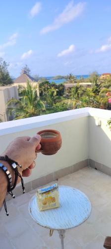 a person holding a football on a balcony with a table at Casa Maridadi in Watamu