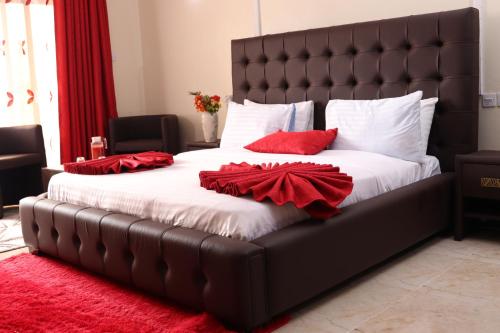 a large bed with red pillows on it at White Peacock Resort Mtwapa in Mombasa