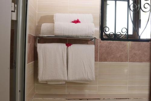 a group of towels on a towel rack in a bathroom at White Peacock Resort Mtwapa in Mombasa