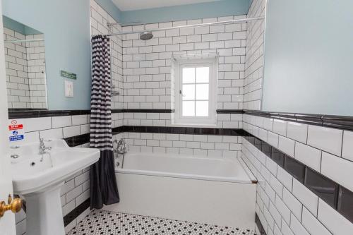 a white bathroom with a tub and a sink at Westholme Lodge in Minehead