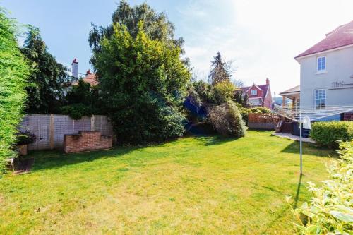 a yard of a house with a fence and trees at Westholme Lodge in Minehead