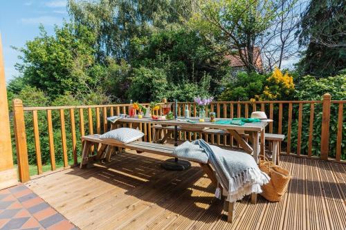 a wooden deck with a table and chairs on it at Westholme Lodge in Minehead