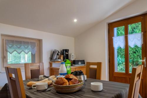 a dining room table with a basket of bread on it at La maison rocher in Fournels