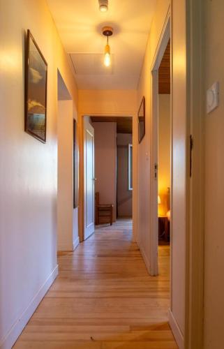 a hallway of an apartment with wooden floors and white walls at La maison rocher in Fournels