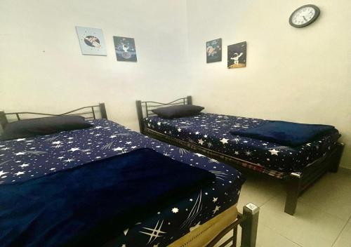 two beds sitting next to each other in a bedroom at Sulong Inn - Private Pool Homestay in Kuantan, Pantai Sepat in Kuantan
