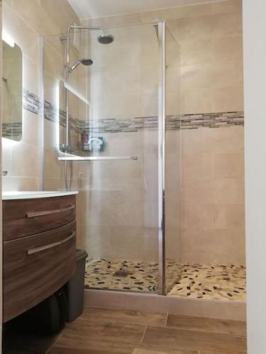 une salle de bain avec une douche avec un lavabo et une baignoire dans l'établissement Accès direct plage, à Hyères