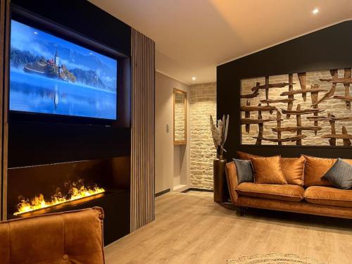 - un salon avec un canapé et une grande télévision dans l'établissement Logement spa privatif proche Niort et La Rochelle, à Arçais