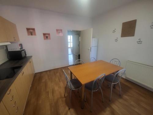 a kitchen with a wooden table and chairs at Danubius Szálló in Komárno