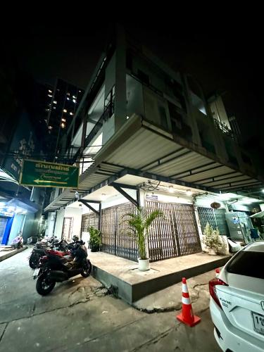 a motorcycle parked in front of a building at night at The White Den Chatuchak in Bang O
