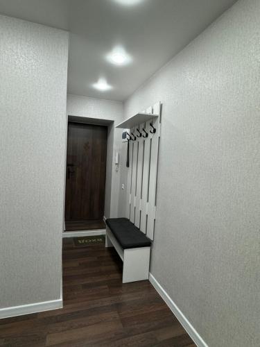 a hallway with a staircase with a bench and a door at Люкс в центре Караганды in Karagandy