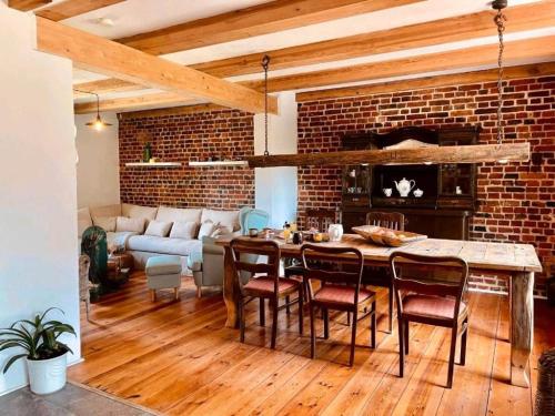a living room with a brick wall and a table and chairs at Ferienhaus am Rande des Spreewald in Heinersbrück