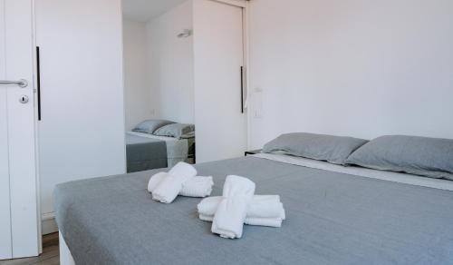 Un dormitorio con una cama con toallas blancas. en Aosta Theater Home, en Aosta