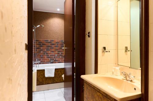 une salle de bain avec un lavabo et une douche dans l'établissement Aux Prisons de Montagny, à Montagny