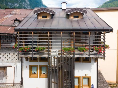 a building with potted plants on the windows at Albergo Diffuso Dolomiti in Forni di Sotto
