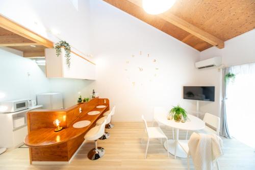 a kitchen and dining room with a wooden table and chairs at Miraie Yokkaichi Hinaganishi in Nishi-hino