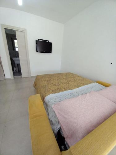 a bedroom with a bed and a tv on the wall at Red House- Camera per quattro in Montecorvino Rovella