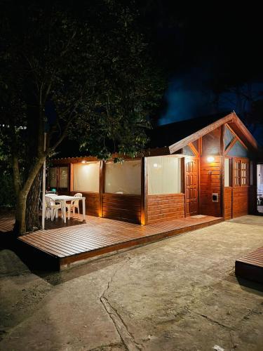 a small cabin with a table and chairs on a deck at Cabañas Entre Pinos in Villa Gesell