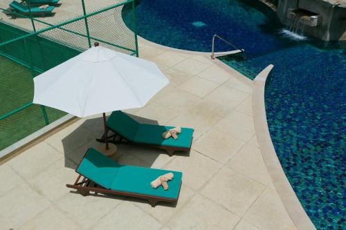 an overhead view of two chairs and an umbrella next to a swimming pool at Katamanda Villa Mila A1 near Kata Beach in Kata Beach