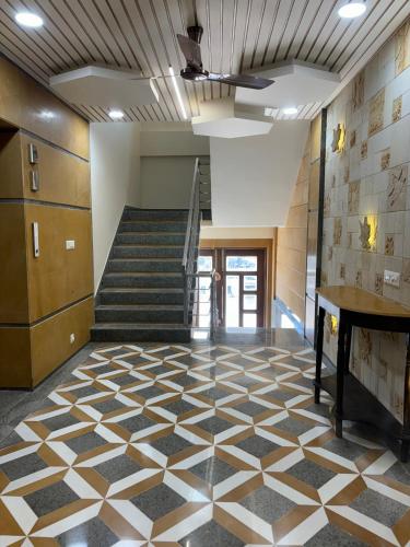 a lobby with a staircase and a checkered floor at Hotel M R Paradise in Jaisalmer