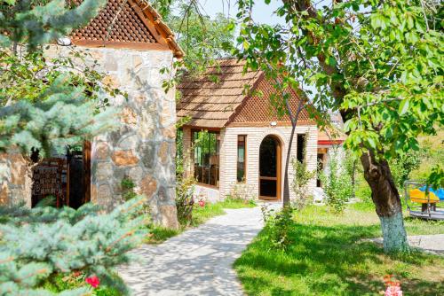 a stone house with a pathway leading to a yard at Qachaquch Forest in Qusar