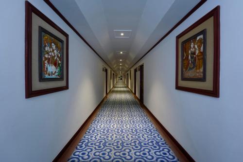 a long hallway with paintings on the walls at Casino Hotel - CGH Earth, Cochin in Cochin