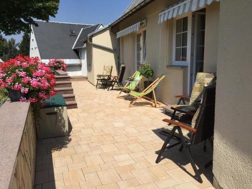 a patio with chairs and flowers on a building at Berghotel Talblick in Holzhau