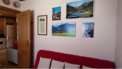 a living room with a red couch and pictures on a wall at Apartament Era de Dalt Barruera in Barruera