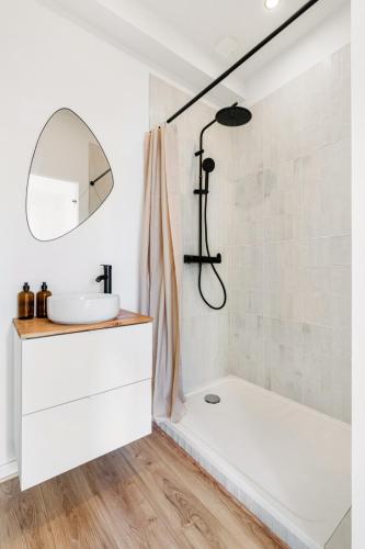 une salle de bain avec une baignoire blanche et un lavabo dans l'établissement Adélaïde loft scandinave - 4 chambres 4 SDB, à Saint-Étienne