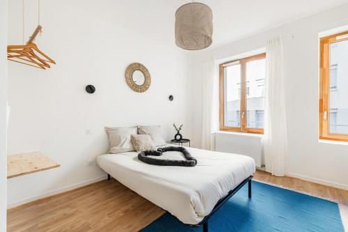 - une chambre aux murs blancs et un lit dans un dortoir dans l'établissement Adélaïde loft scandinave - 4 chambres 4 SDB, à Saint-Étienne