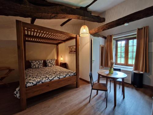 a bedroom with a wooden bed and a table with a chair at Château de la Mothe de Vicq - Allier, à proximité de Vichy in Vicq