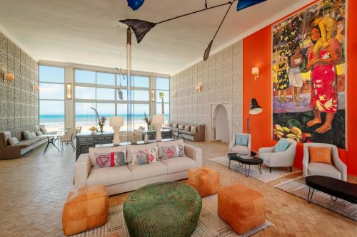 a living room with a white couch and orange walls at Kasbah d'Eau in Sidi Kaouki